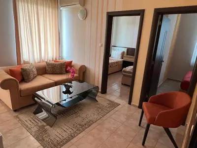 a living room with a couch and a table and a chair at Hotel Lazur in Kiten