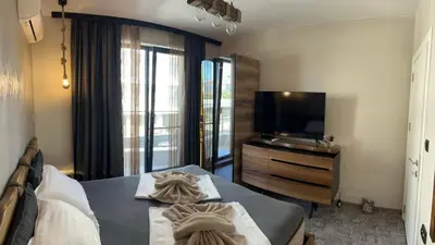 a hotel room with a bed and a television at Magic Home in Obzor