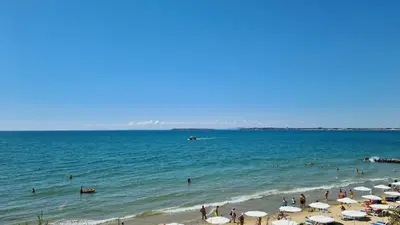 a group of people on a beach with umbrellas at Apartment mit Meeresblick Polarstar Beach 2 Zimmer Premium Apartment in Sveti Vlas