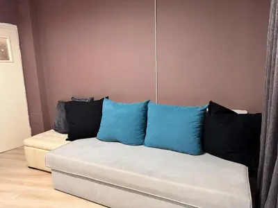 a couch with blue and black pillows on it at Cozy Central Apartment Steps from Everything! in Varna City