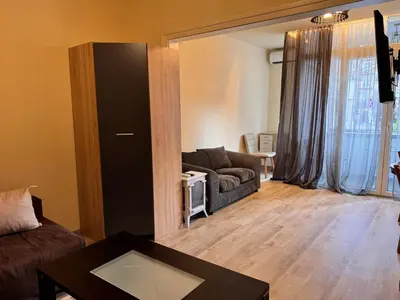 a living room with a couch and a table at Cozy Central Apartment Steps from Everything! in Varna City
