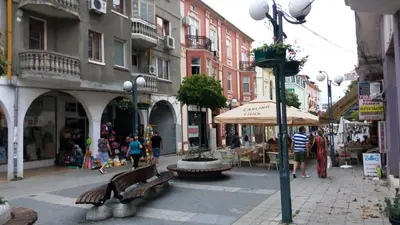 a city street with benches and tables and buildings at Luxury Apartments Central KIRIL I METODII 3 in Burgas City