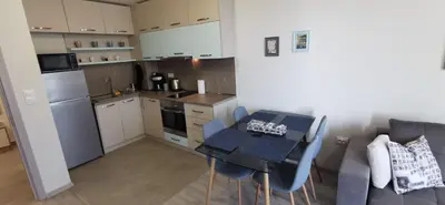 a kitchen with a table and chairs in a room at Ах, морето 2 in Burgas City