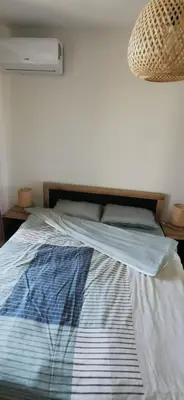 a bed with a blue and white comforter in a bedroom at Ах, морето 2 in Burgas City