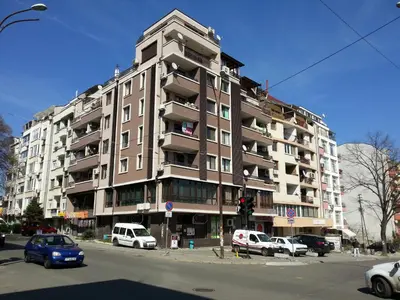 a tall building with cars parked in front of it at Apartment Nova in Burgas City