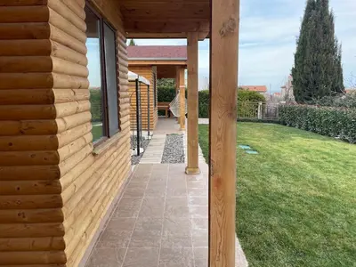 a wooden house with a walkway next to a yard at Вили Панорама 2 in Chernomorets