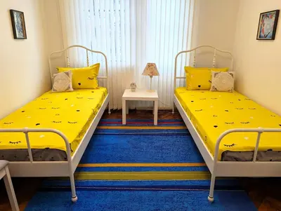 two beds in a room with yellow sheets at Seaside luxury residence in Varna City