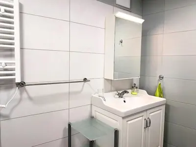 a white bathroom with a sink and a mirror at Seaside luxury residence in Varna City