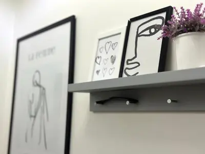 a shelf with two pictures and a plant on a wall at Studio Sea Garden in Varna City