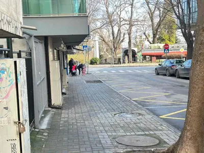 a street with people walking down a sidewalk next to a building at Studio Sea Garden in Varna City