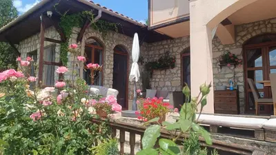 a stone house with flowers in front of it at къща за гости villa Jurta in Avren