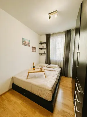 a bedroom with a bed with a table on it at Smile City Apartment in Varna City