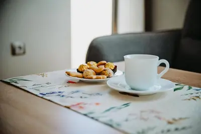 a table with a cup of coffee and a plate of pastries at Smile City Apartment in Varna City