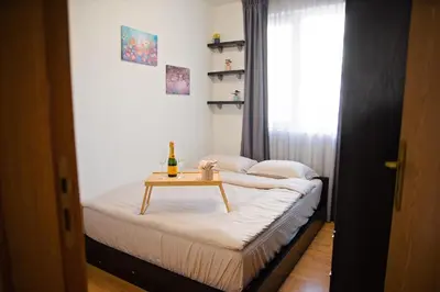 a small room with a bed with a table on it at Smile City Apartment in Varna City