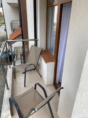 a balcony with two chairs and a window at Апартамент Дани in Obzor