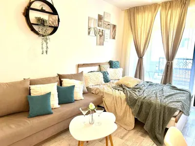 a living room with a couch and a table at Студио в Затворен Комплекс Green in Sozopol