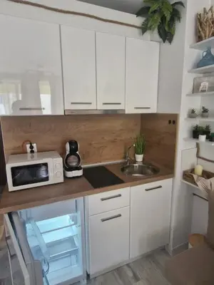a kitchen with white cabinets and a sink and a microwave at Студио в Затворен Комплекс Green in Sozopol