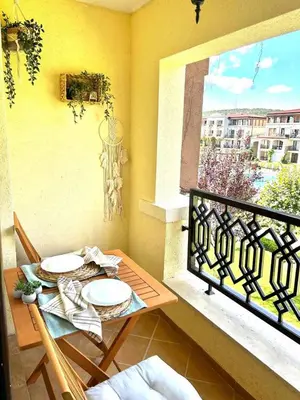 a table and chairs on a balcony with a window at Студио в Затворен Комплекс Green in Sozopol
