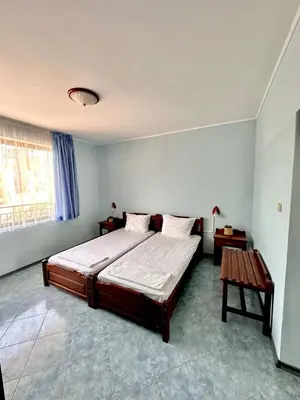 a bedroom with a large bed and a table at Vila Victoria Primorsko in Primorsko