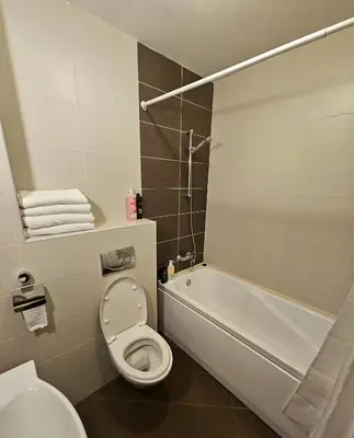 a bathroom with a toilet and a tub and a sink at Двустаен апартамент Поморие in Pomorie