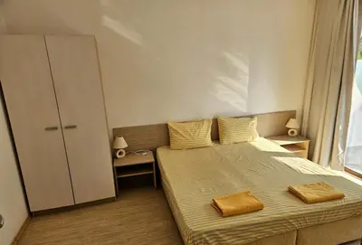 a bedroom with a bed with two towels on it at Двустаен апартамент Поморие in Pomorie