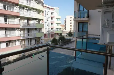 an empty balcony of a building with a bird on the railing at SUN GATE - Julia in Sunny Beach