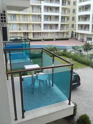 a balcony with a table and chairs and a building at SUN GATE - Kamil in Sunny Beach