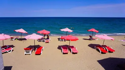 a group of chairs and umbrellas on a beach at Апартамент Деа - Apartment Dea in Byala