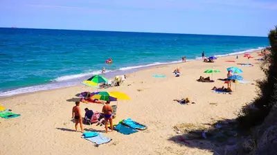 a group of people on a beach with umbrellas at Апартамент Деа - Apartment Dea in Byala