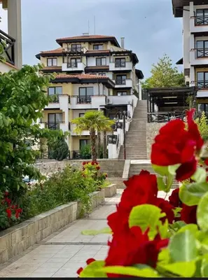 a large building with stairs and red flowers in front of it at Relaxing apartment - 100 meters from the sea in Chernomorets