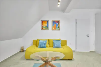 a living room with a yellow couch and a glass table at MAESTRA Bamboo Beach Luxury Apartment - FREE Parking in Sozopol