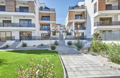 an apartment building with a lawn in front of it at MAESTRA Bamboo Beach Luxury Apartment - FREE Parking in Sozopol