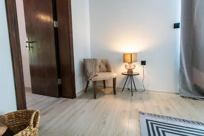 a living room with a chair and a lamp at Bella Mare Boutique apartment in Sunny Beach