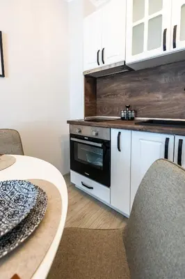a kitchen with white cabinets and a stove at Bella Mare Boutique apartment in Sunny Beach
