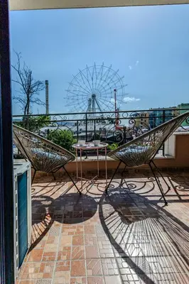 a patio with two chairs and a table and a ferris wheel at Bella Mare Boutique apartment in Sunny Beach