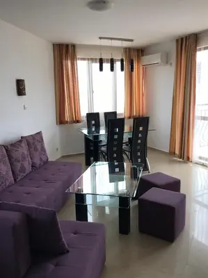 a living room with a couch and a glass table at Apartment Slantse in Sozopol