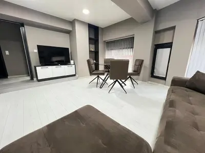 a living room with a couch and a table with chairs at NJ Modigliani style in Varna City