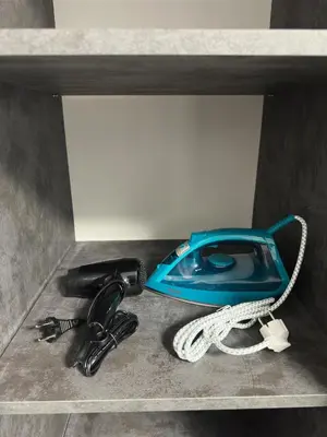a phone and a hair dryer on a shelf at Sea in Varna City