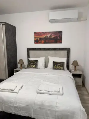 a bedroom with a large white bed with two lamps at Sea in Varna City