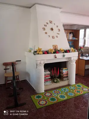 a fireplace with a clock on top of it at International 2-star spacious 88 sq m apartment in Varna City