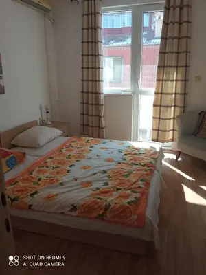 a bedroom with a bed with a floral blanket on it at International 2-star spacious 88 sq m apartment in Varna City