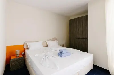 a bedroom with a white bed with a towel on it at APOLONIS hotel in Sozopol