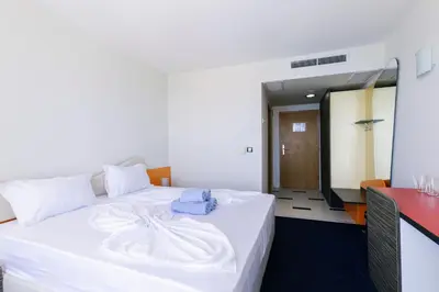 a hotel room with a white bed with a towel on it at APOLONIS hotel in Sozopol