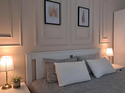 a bedroom with a bed with two pillows and two lamps at Varna Moreto in Varna City