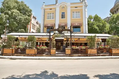 a building with tables and chairs in front of it at Varna Moreto in Varna City