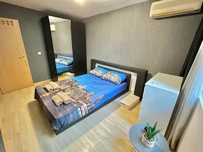 a bedroom with a blue bed and a mirror at Black Sea Varna Centre in Varna City