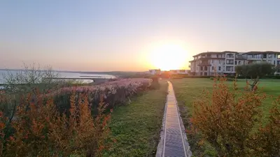 a train track next to the water with a building at АМИРА апартамент за гости - AMIRA guest apartment in Burgas City