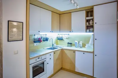 a kitchen with white cabinets and a sink at Villa Mare Boutique Guesthouse by Flat Mаnаger in Pomorie