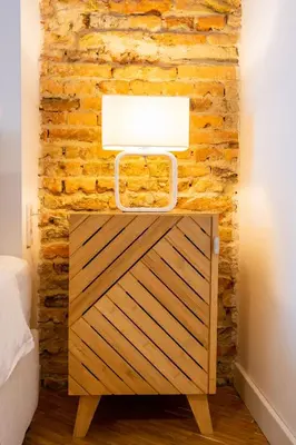 a bedside table with a light on a brick wall at Apartment Musala N 01 in Varna City