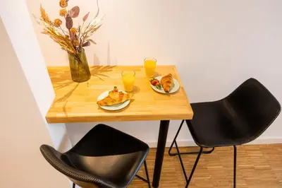 a table with two chairs and a plate of food and drinks at Apartment Musala N 01 in Varna City